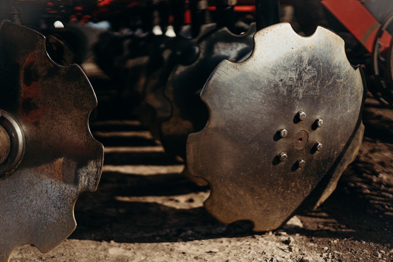 Detailed view of metallic plow discs, showcasing texture and design in natural light.